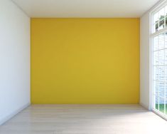 an empty room with yellow walls and white floors