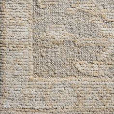 an area rug with squares and lines on the top, in neutral colors is shown