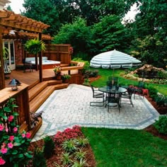 an outdoor patio with table and chairs next to the hot tub in the back yard