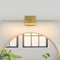 an arch in the wall with a potted plant on it and a light fixture above