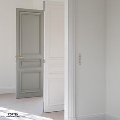 an empty room with white walls and doors