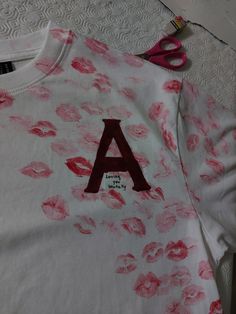 a t - shirt with the letter a drawn on it and scissors next to it