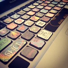 an open laptop computer sitting on top of a white table covered in stickers and magnets