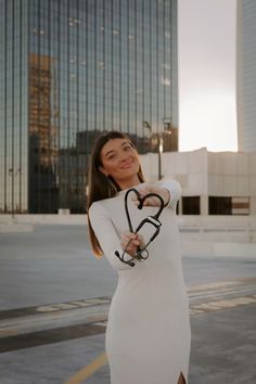 a woman wearing a white dress and holding a stethoscope in her hand