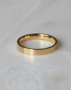 a gold wedding ring sitting on top of a white sheet