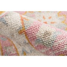 a close up view of the fabric on a colorful floral print couch cushion, with white and pink accents