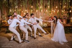 a group of people standing around each other in front of a table with flowers on it