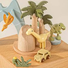 wooden toys including dinosaurs and trees on a table