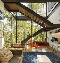 modern living room with stairs leading up to the second floor and large windows on both sides