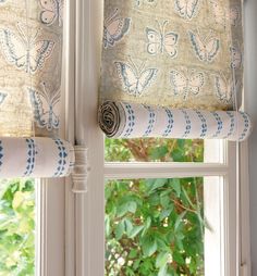 the curtains are hanging on the window sill in the room that is decorated with blue and white butterflies