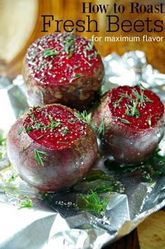 three beets sitting on top of aluminum foil covered in red sauce and sprinkled with herbs