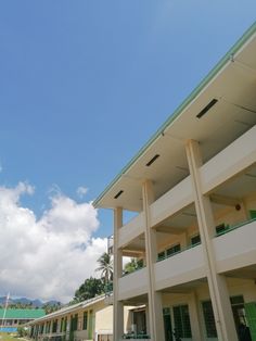 the outside of a building with green shutters and balconies on both sides