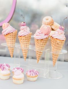 cupcakes and ice cream cones are on display