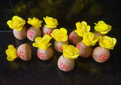 some yellow flowers are placed in the middle of small eggs on a black countertop