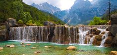 the waterfall is surrounded by rocks and green water