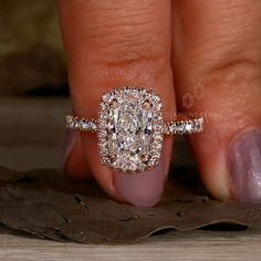 a woman's hand with a diamond ring on top of her finger and an engagement band