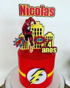 a birthday cake with the flash logo on top and an image of a hero jumping out of it