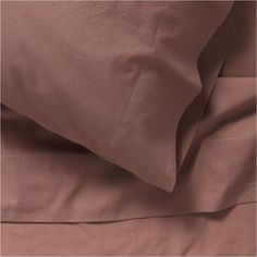 the sheets and pillowcases are made up in two different shades of pink, brown and white