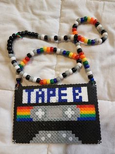 a beaded necklace with the word tahee on it and a rainbow colored cassette