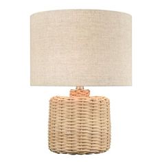 a wicker table lamp with a beige shade