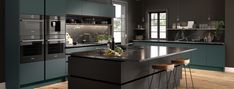 a modern kitchen with an island counter and stools next to the stove, oven and microwave