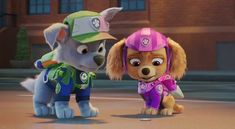 two cartoon dogs standing next to each other in front of a brick building and one dog wearing a helmet