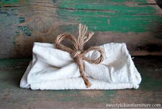 a white towel wrapped in twine and tied with rope on an old wooden table