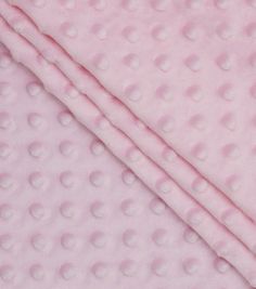 a pink blanket with white polka dots on it