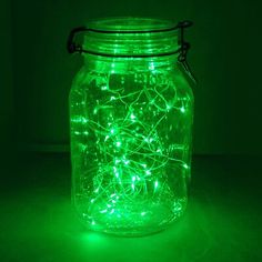 a mason jar filled with green fairy lights