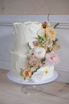 a three layer white cake with flowers on top