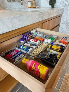 an open drawer in a bathroom filled with toiletries