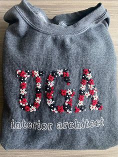 a gray sweatshirt with red and white flowers on it that says usa in sequins