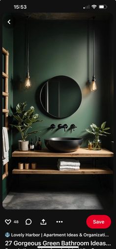 a bathroom with dark green walls and black sink in the middle, surrounded by greenery