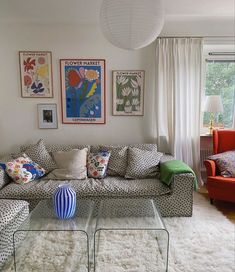 a living room filled with furniture and pictures on the wall