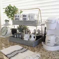 a kitchen counter with coffee cups, mugs and other items sitting on top of it