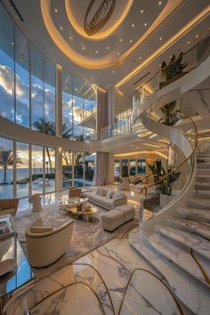 a living room filled with lots of furniture next to large windows and stairs leading up to the second floor