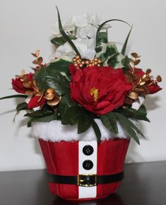 a red and white flower pot with flowers in it