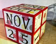 a red and white cube with the word november written on it's sides is sitting on a table