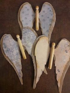 four wooden angel wings are sitting on a table