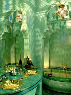 an image of a bathroom with green walls and gold fixtures on the counter top, as well as two sinks