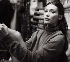 a black and white photo of a woman in a clothing store