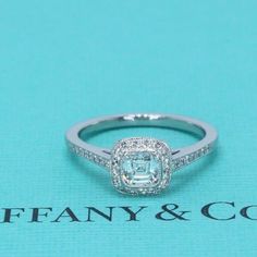 an engagement ring is shown on a blue background with the words tiffany and co written below it