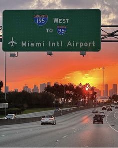 cars driving down the highway in front of a sunset with an overcast sky and palm trees