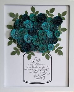 a paper flower arrangement in a white frame with a quote on the bottom that reads life is not measured by the breath we take but by the moments