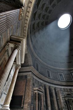 the light shines brightly through the round window in an old building with columns and pillars