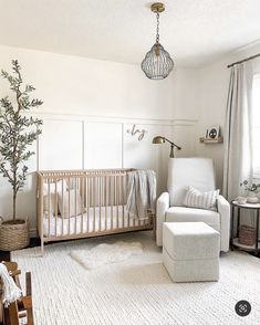 a baby's room with a crib, chair and ottoman