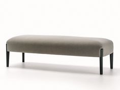 an upholstered bench with black legs on a white background