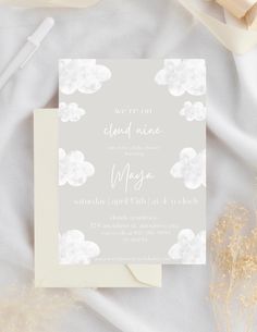 the wedding stationery is laid out on a white cloth with flowers and ribbons around it