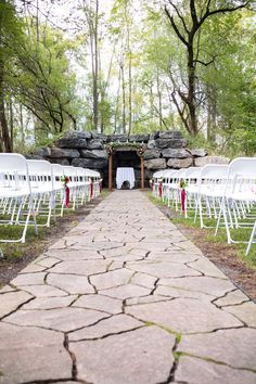 an outdoor ceremony set up with white chairs