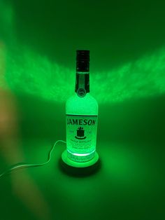 a bottle of jameson on a green background with the light coming from it's top